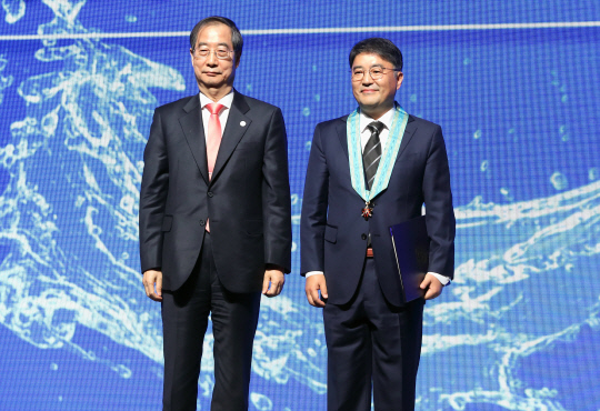 지난 3월 세계 물의 날 기념식에서 동탑산업훈장 수훈 후 한덕수 총리와 기념촬영하고 있는 김동우 대표. 부강테크 제공